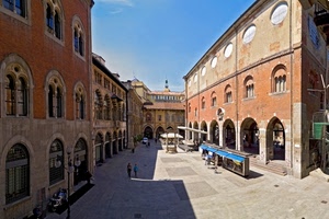 piazza, archi, finestre, palazzi, pozzo, ombra, strada, bancarelle, arcate, portico, passanti